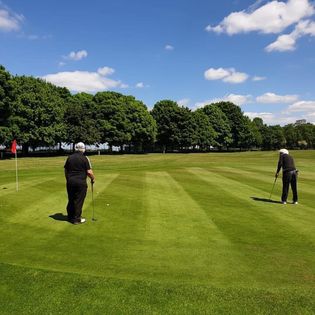 Men playing golf on putting green